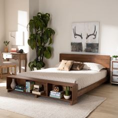 a bed sitting on top of a wooden floor next to a plant