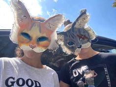 two people with cat masks on their faces