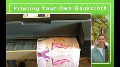 a woman standing in front of a printer with an image of paper birds on it