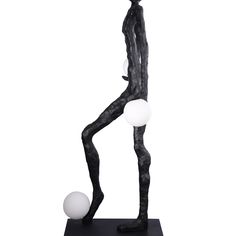 a black and white statue with three balls on it's back legs, standing in front of a white background