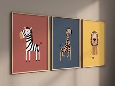 three framed pictures of animals hanging on a wall next to each other, one with a giraffe and the other with a zebra