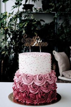 a pink and white cake sitting on top of a table