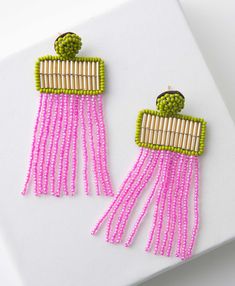 pink and green beaded earrings on white surface