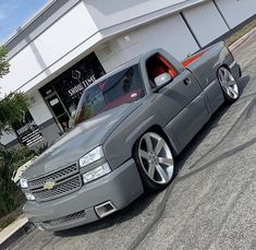 a silver truck parked in front of a building