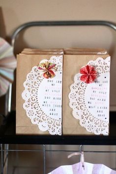 two brown bags sitting on top of a metal rack next to a white doily