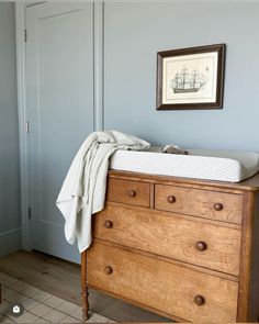 a baby's crib in the corner of a room with a painting on the wall