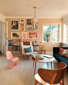 a living room filled with furniture and pictures on the wall