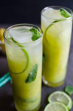 two glasses filled with lemonade and lime slices