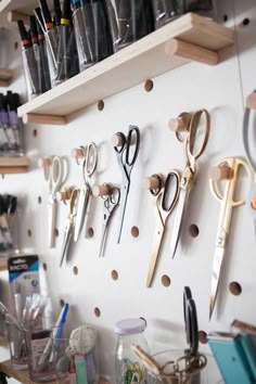 there are many pairs of scissors hanging on the wall