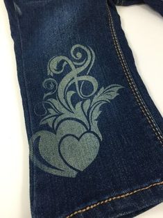 a pair of jeans with an embroidered heart on it