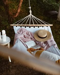 a person laying in a hammock with a hat on