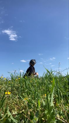 a person sitting in the middle of a grassy field