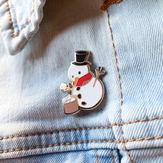 a snowman wearing a top hat and holding a coffee cup in his lapel