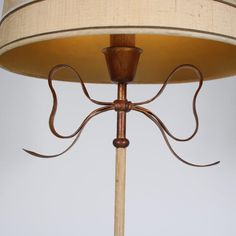 a lamp that is sitting on top of a wooden pole with a light shade over it