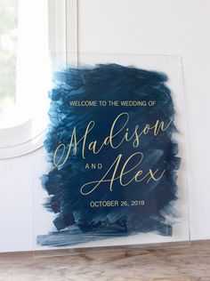 an acrylic sign with the words, welcome to the wedding of madison and alex