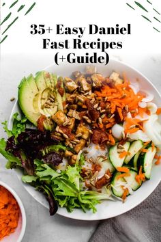 a white plate topped with salad next to carrots and cucumbers