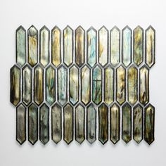 an art piece made out of metal and mother of pearles on a white wall