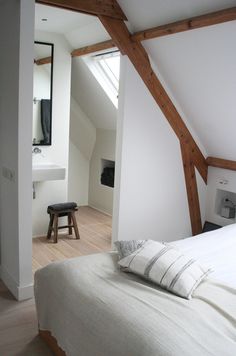 an attic bedroom with white walls and wooden beams