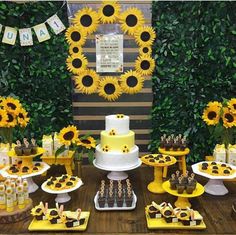 a table with sunflowers and cakes on it