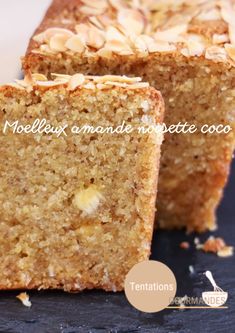 two pieces of cake sitting on top of a black plate next to each other with almonds