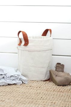 a pair of shoes sitting next to a bag on the floor with clothes in it