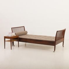 a wooden bench sitting next to a table on top of a white floor covered in books