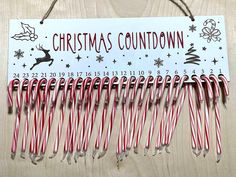 a wooden sign with candy canes hanging from it's sides