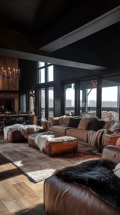 a living room filled with lots of furniture next to a fire place and large windows