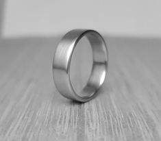 Here I present to you a handmade titanium band with slightly rounded edges for more comfortable wear. This ring is suitable for men and women as it is classic in a minimalist style and is therefore suitable for all occasions as well as everyday wear. The ring presented is made in US size 9 and is 6 mm wide. You can choose between different sizes and widths. This titanium simple ring is not only visually stunning, but also comfortable to wear. The smooth interior ensures a comfortable fit, while Husband Ring, His And Her Wedding Rings, Everyday Rings, Classic Ring, Rings Simple, Gifts For Husband, Silver Band, Ring Gift, Minimalist Fashion