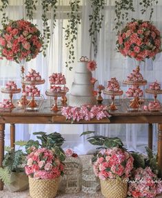 a table topped with lots of pink flowers and desserts on top of wooden tables