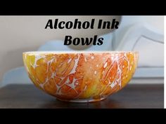 an orange and white bowl sitting on top of a wooden table