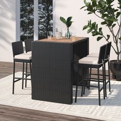 an outdoor table and chairs set up on a patio with potted plant in the background