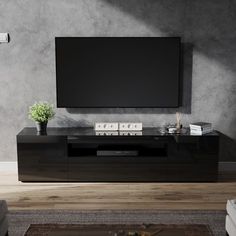 an entertainment center with a flat screen tv mounted on it's side, in front of a gray wall