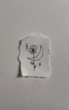 a piece of paper that has been torn in half with a flower drawn on it