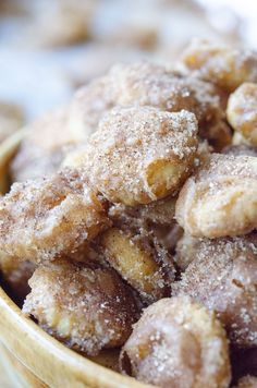 a wooden bowl filled with sugar covered donuts