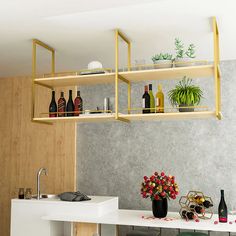 a kitchen counter with bottles and flowers on the top shelf, next to a sink