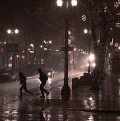 two people walking in the rain at night