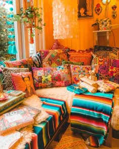 a living room filled with lots of colorful pillows and blankets on top of a couch