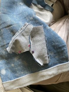 an old pair of jeans is sitting on top of a piece of paper that has been folded