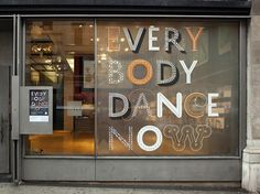 an entrance to a building with a sign on the door that says very body dance no