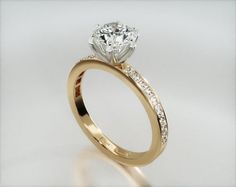 a close up view of a diamond ring on a white background with the center stone in gold