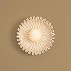 a white scallop shaped light fixture on a wall