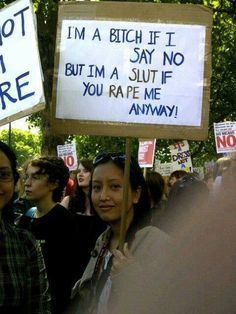 some people holding up signs in front of trees