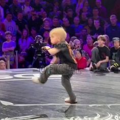 a young boy is dancing in front of an audience