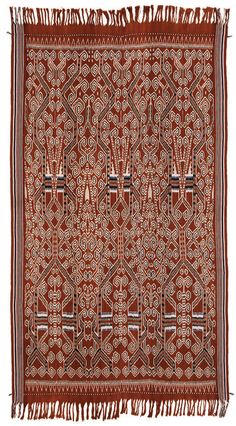 an old red and white rug with fringes