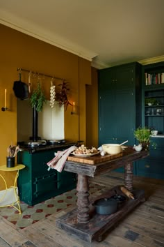 a kitchen with yellow walls and green cabinets, an old fashioned stove top is in the center