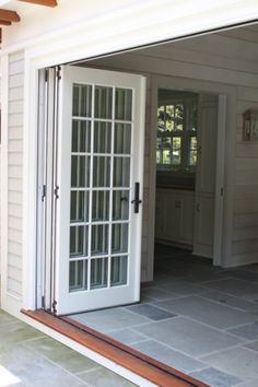 an open patio door with glass panels on the outside and inside doors to another room