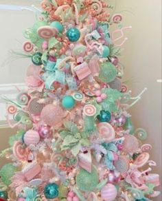 a pink christmas tree decorated with candy and candies