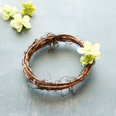 a close up of a wreath on a table with flowers in the middle and one behind it