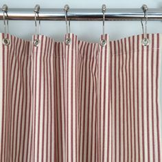 a red and white striped curtain hanging from a metal rod with two hooks on it